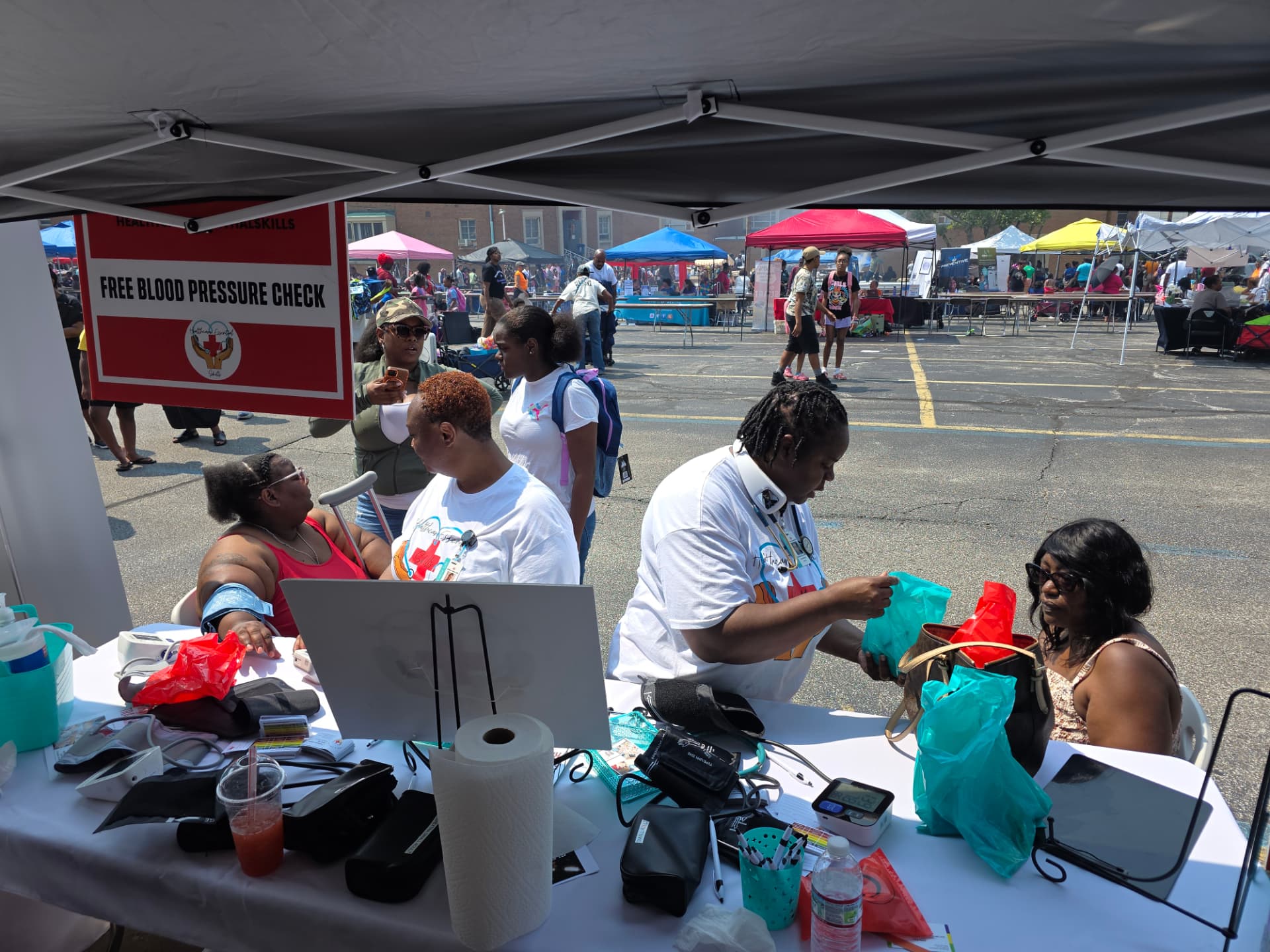 Nurse taking a resident's blood pressure at a community outreach tent